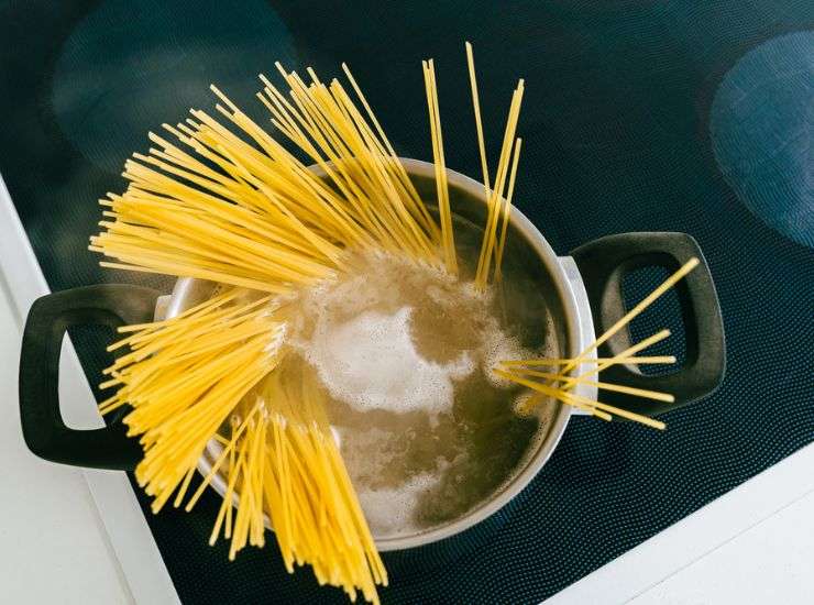 Pentola con acqua di cottura e spaghetti