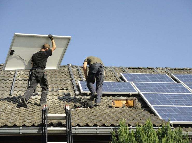 Operai montano pannelli solari sul tetto di una casa 