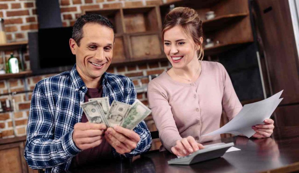 Giovane coppia felice con del denaro in mano