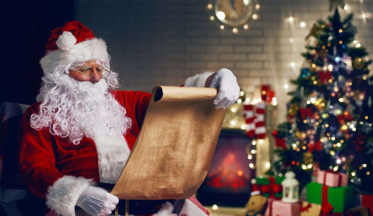 Babbo Natale con lista dei regali e albero addobbato con doni 