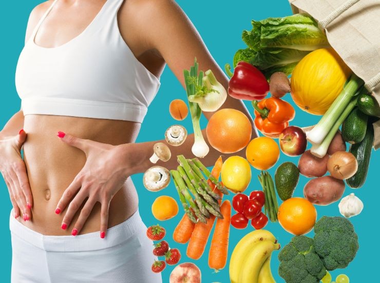 Donna in forma e montagna di ortaggi e frutta che esce dalla busta della spesa