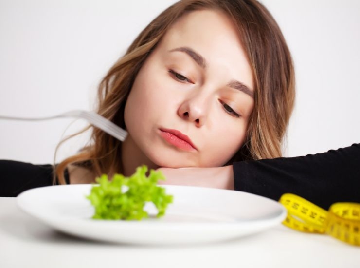 Ragazza a dieta che mangia insalata